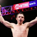 Un boxeador levantando los puños en señal de triunfo después de una pelea, con luces de fondo y el logo de Showtime.